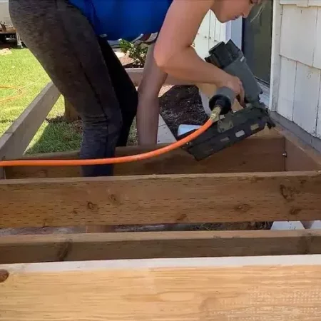 woman nailing in joists for a small front porch