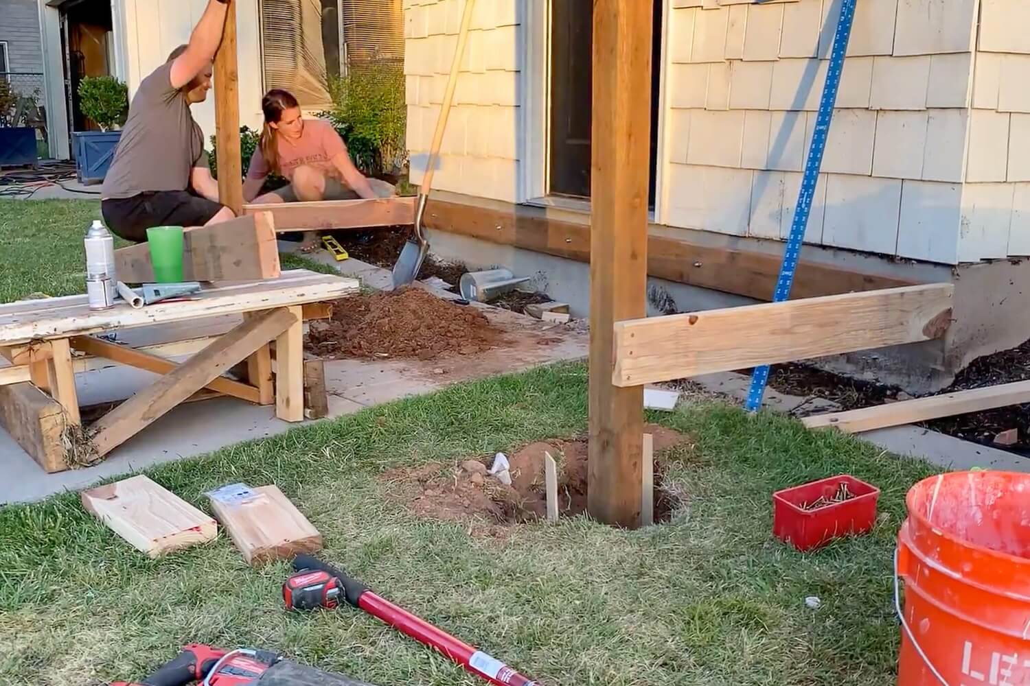 Setting the 4x4 support posts and building out the porch frame next to the house.