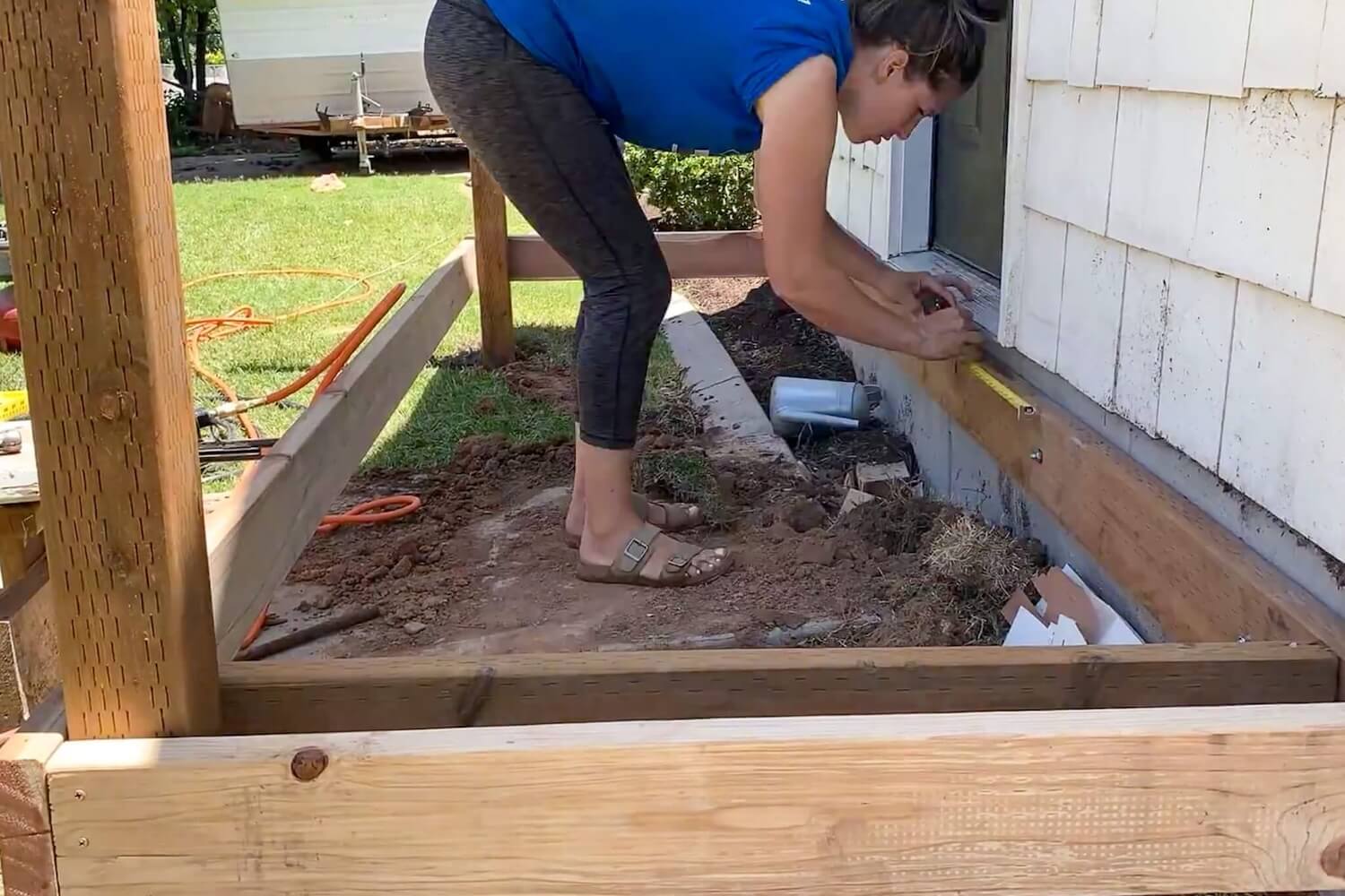 Installing deck joists 16 inches on center across the porch frame.