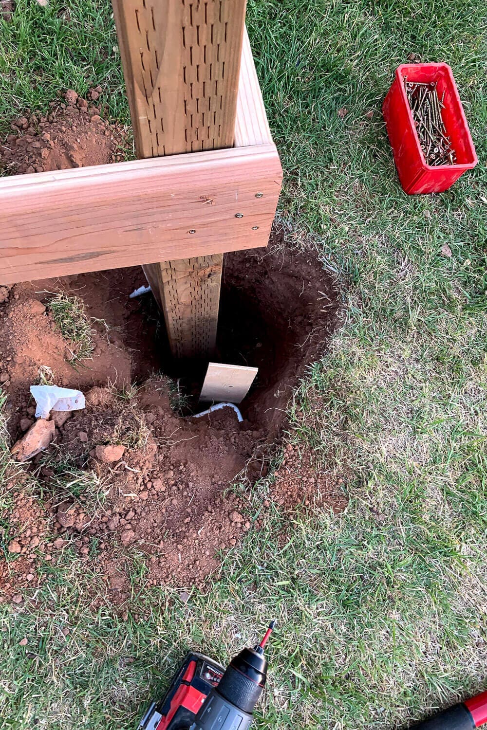 A support post set in a concrete-filled footing with the rim joist attached.