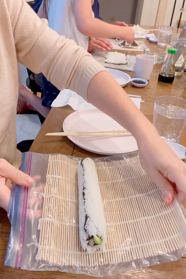 woman rolling up California roll