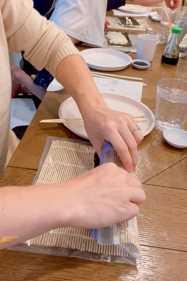 woman rolling up sushi