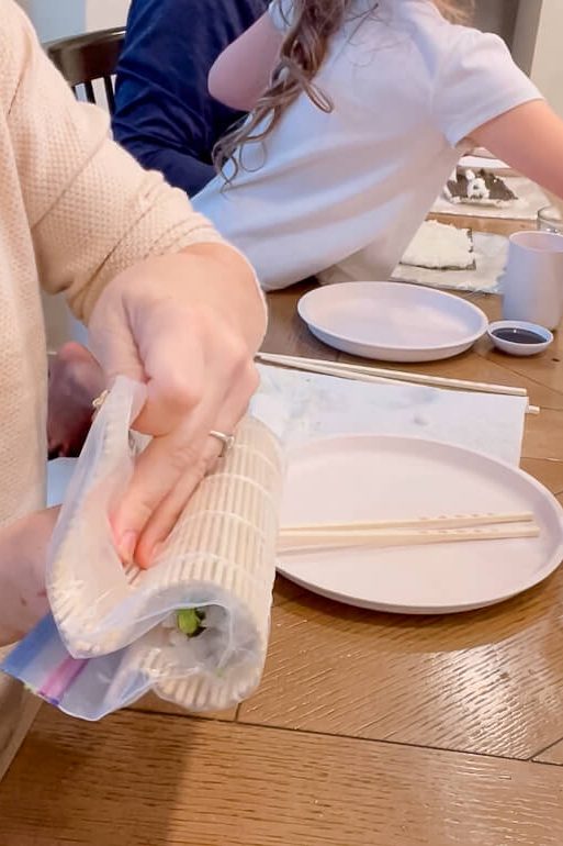 woman rolling up sushi roll