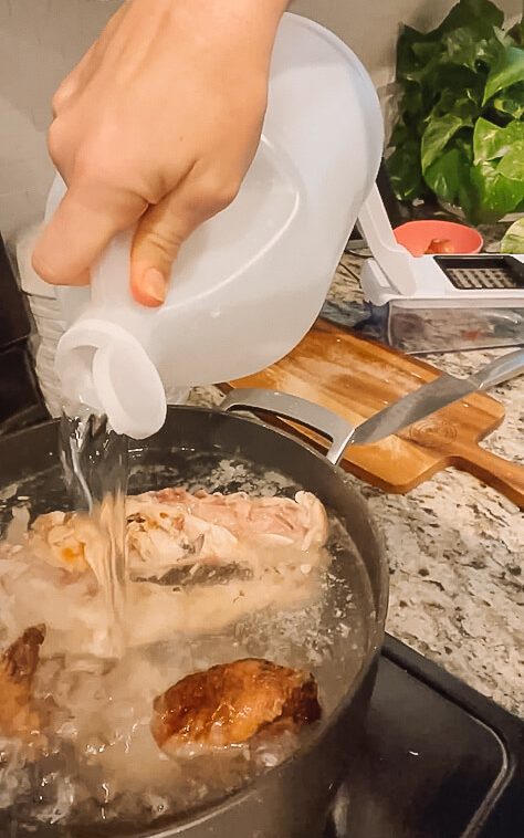 pouring vinegar into bone broth