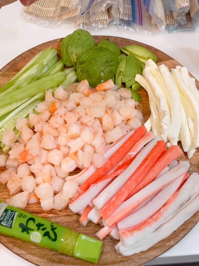 meat and vegetables on a platter for sushi