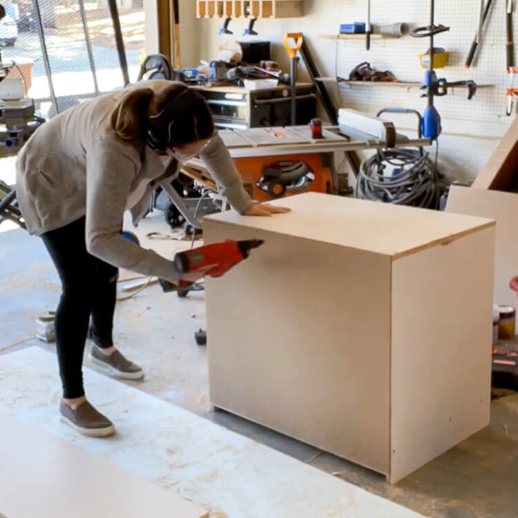 woman screwing together a cabinet for a home office