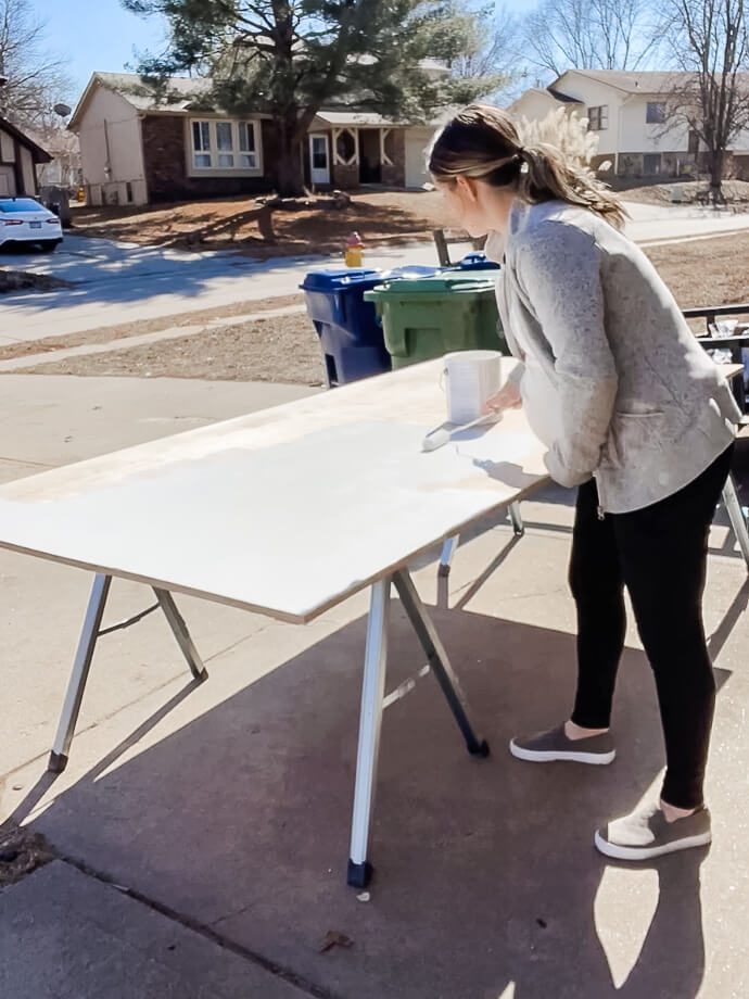 woman painting plywood for a home office built