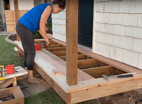 woman drilling wood for a small front deck