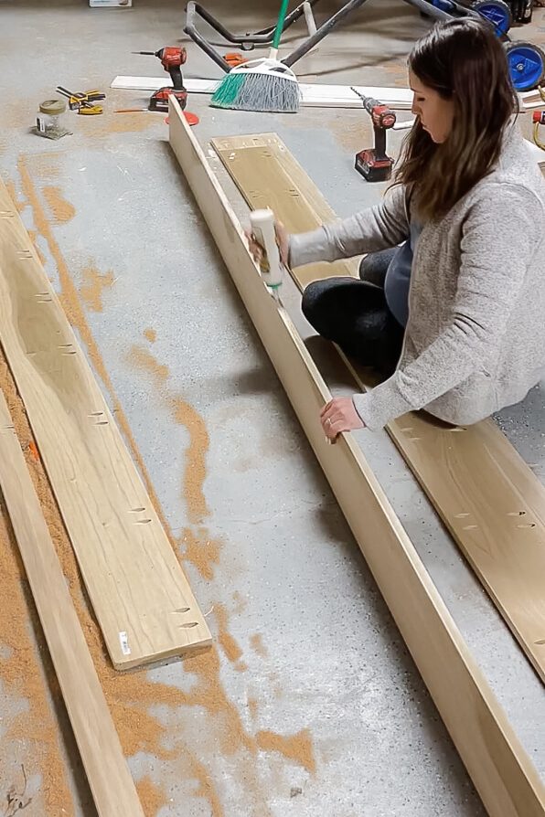 woman applying wood glue to desk top