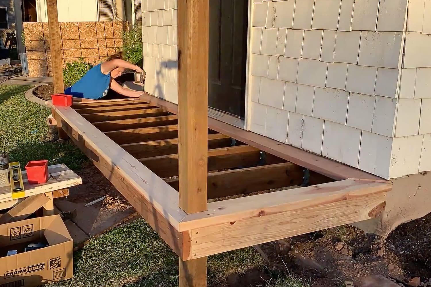 Mitered border trim installed around the porch frame with the floor joists still exposed.