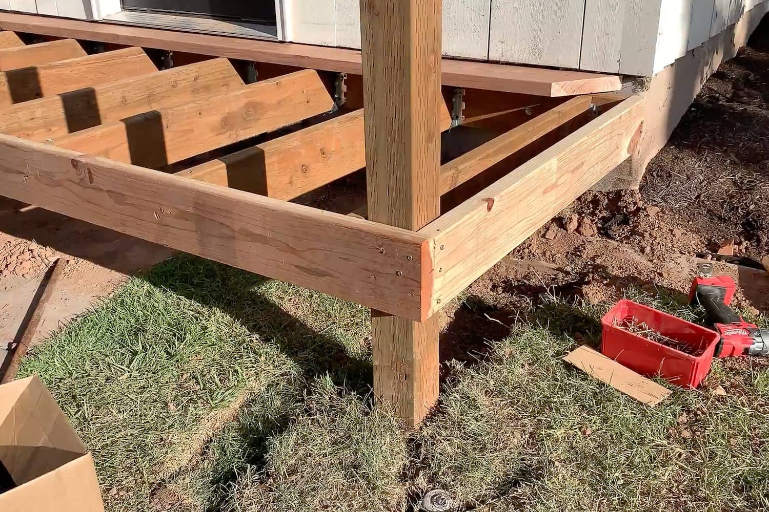 Mitered redwood border trim fastened around the porch frame and notched around a support post.