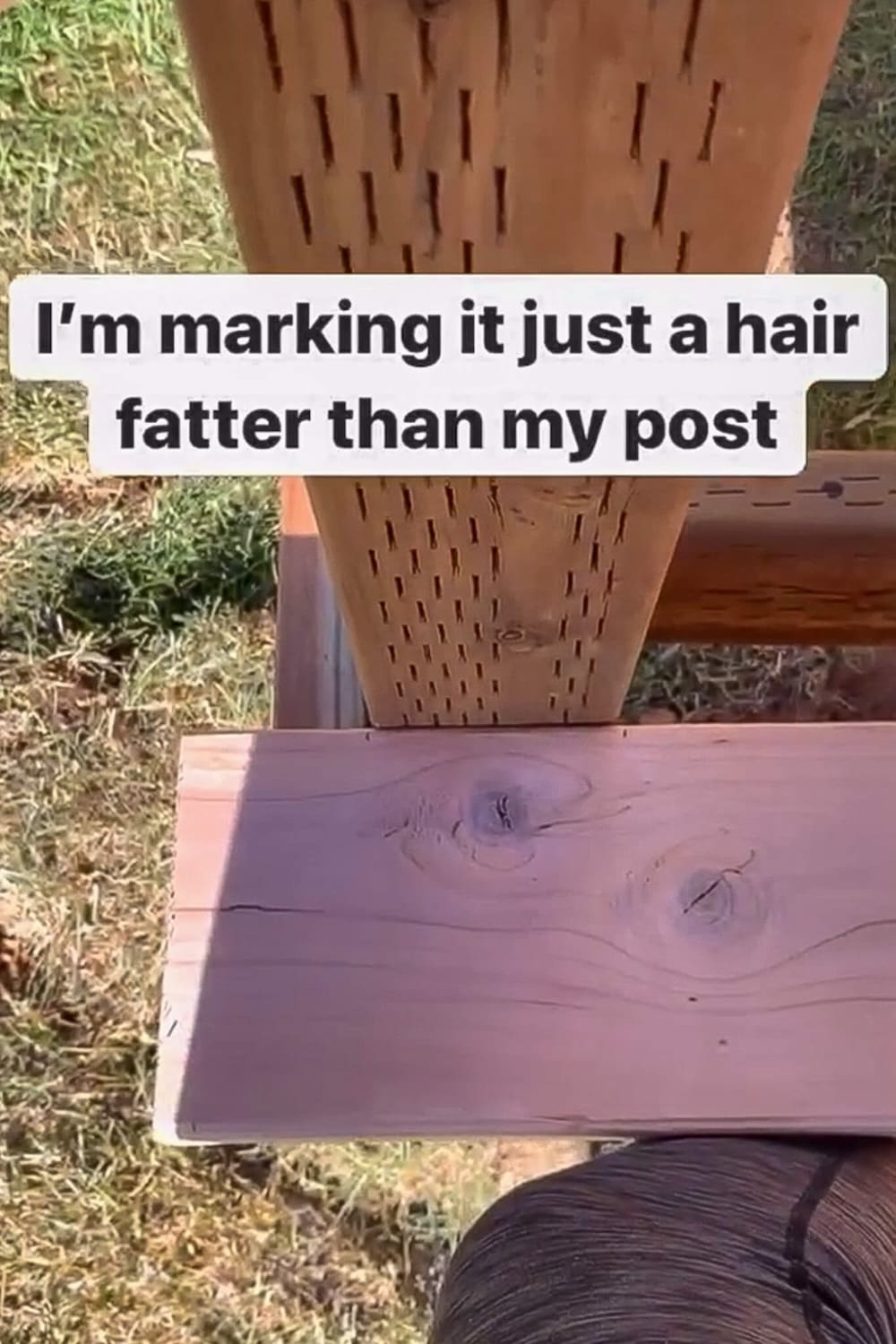 Trim board held against a porch post and marked with a pencil to lay out the notch.