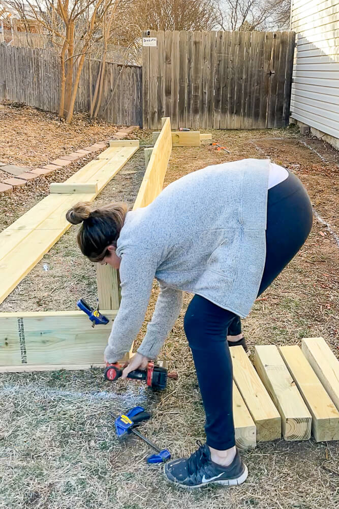 woman building a raised garden bed