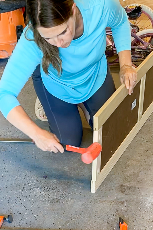 woman using rubber mallet for a shaker door