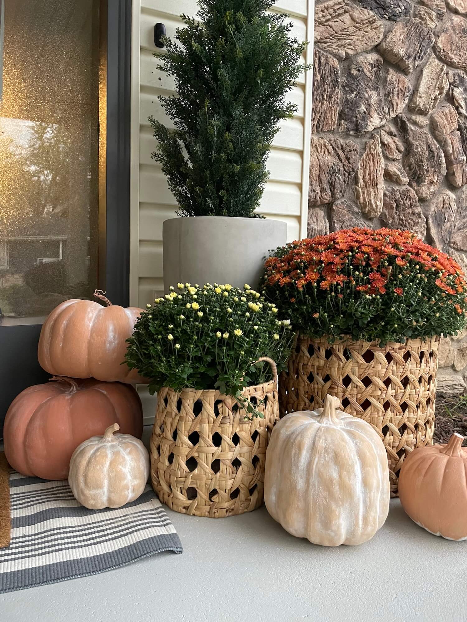 Three painted pumpkins with a clay-like finish styled outside as part of easy DIY autumn decor.