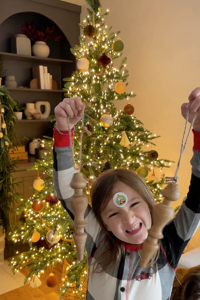 girl holding wood finial christmas tree ornaments