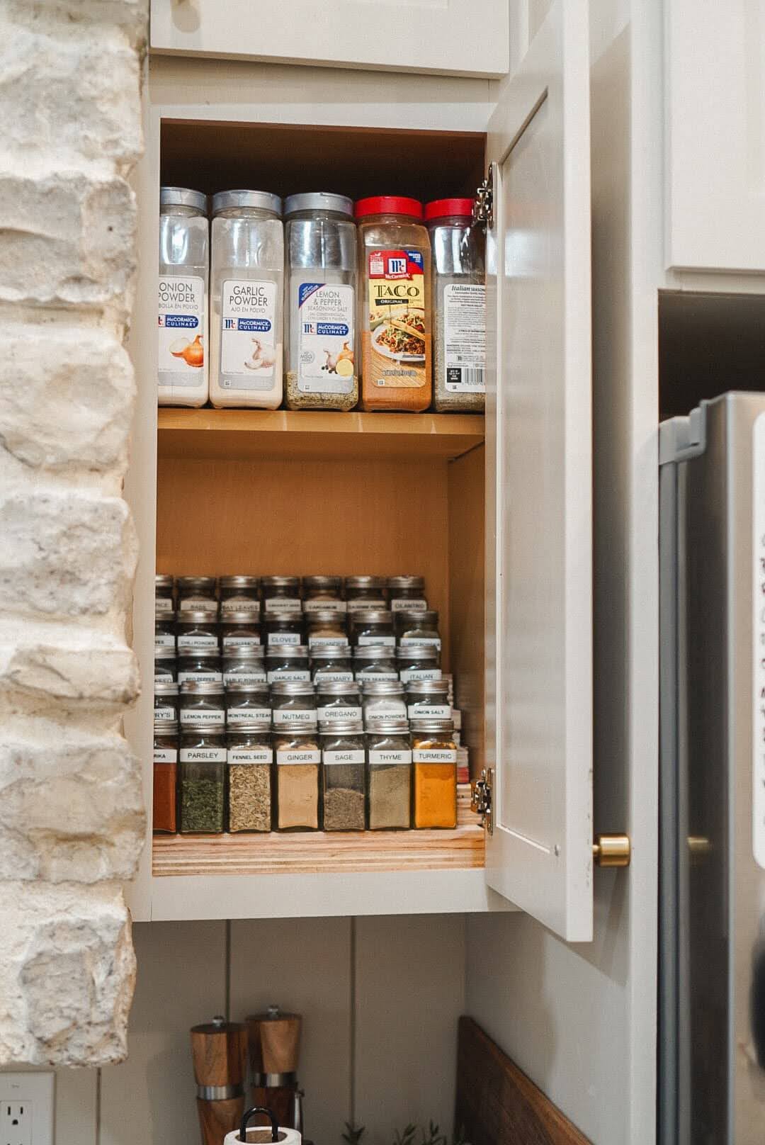 Pretty and organized DIY tiered spice rack in kitchen cabinet