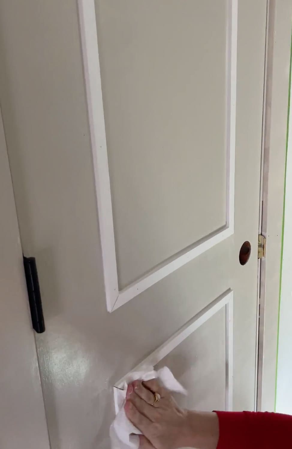 Wiping caulk smooth on interior door trim panel DIY makeover