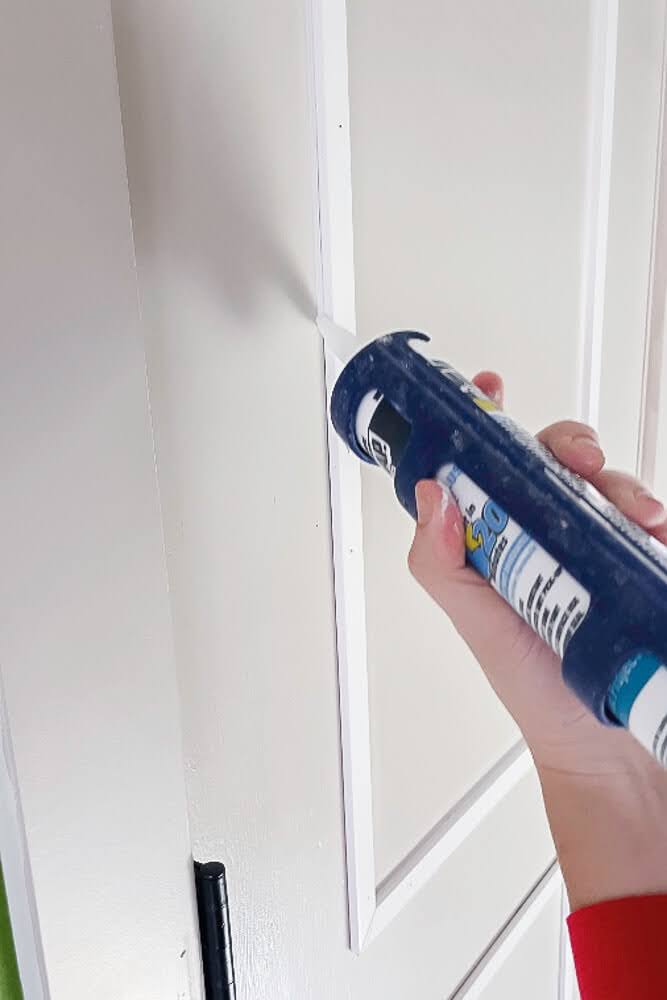 caulking door trim seam on DIY door makeover