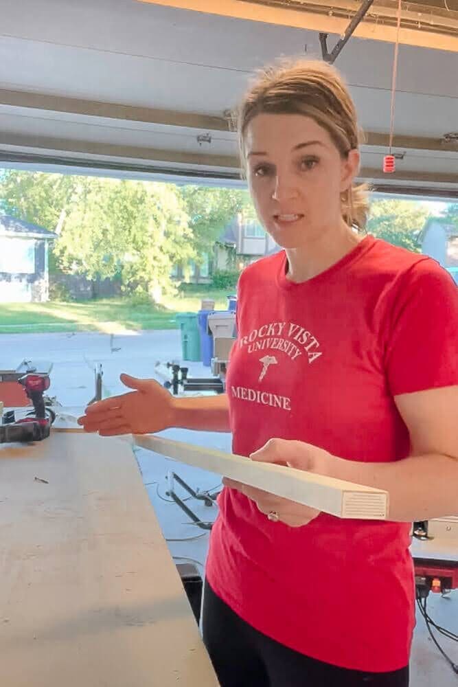 Close-up of a wooden board being marked for precise cuts to build DIY pull-out shelves, ensuring a custom fit for a kitchen cabinet upgrade.