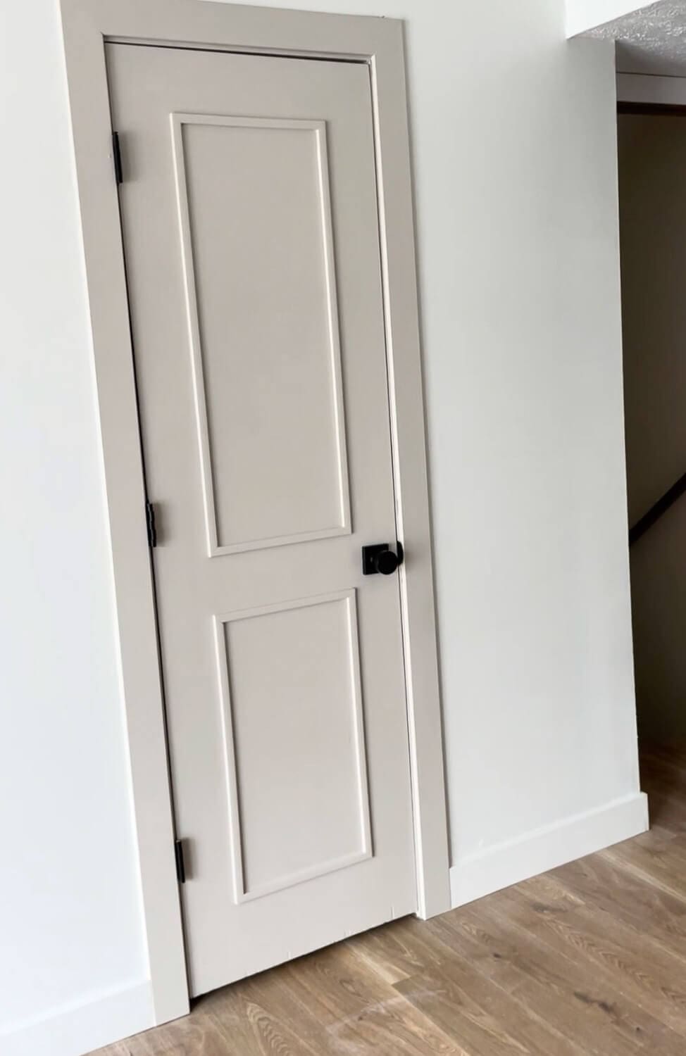 Finished hallway interior door upgrade with trim panels and black hardware