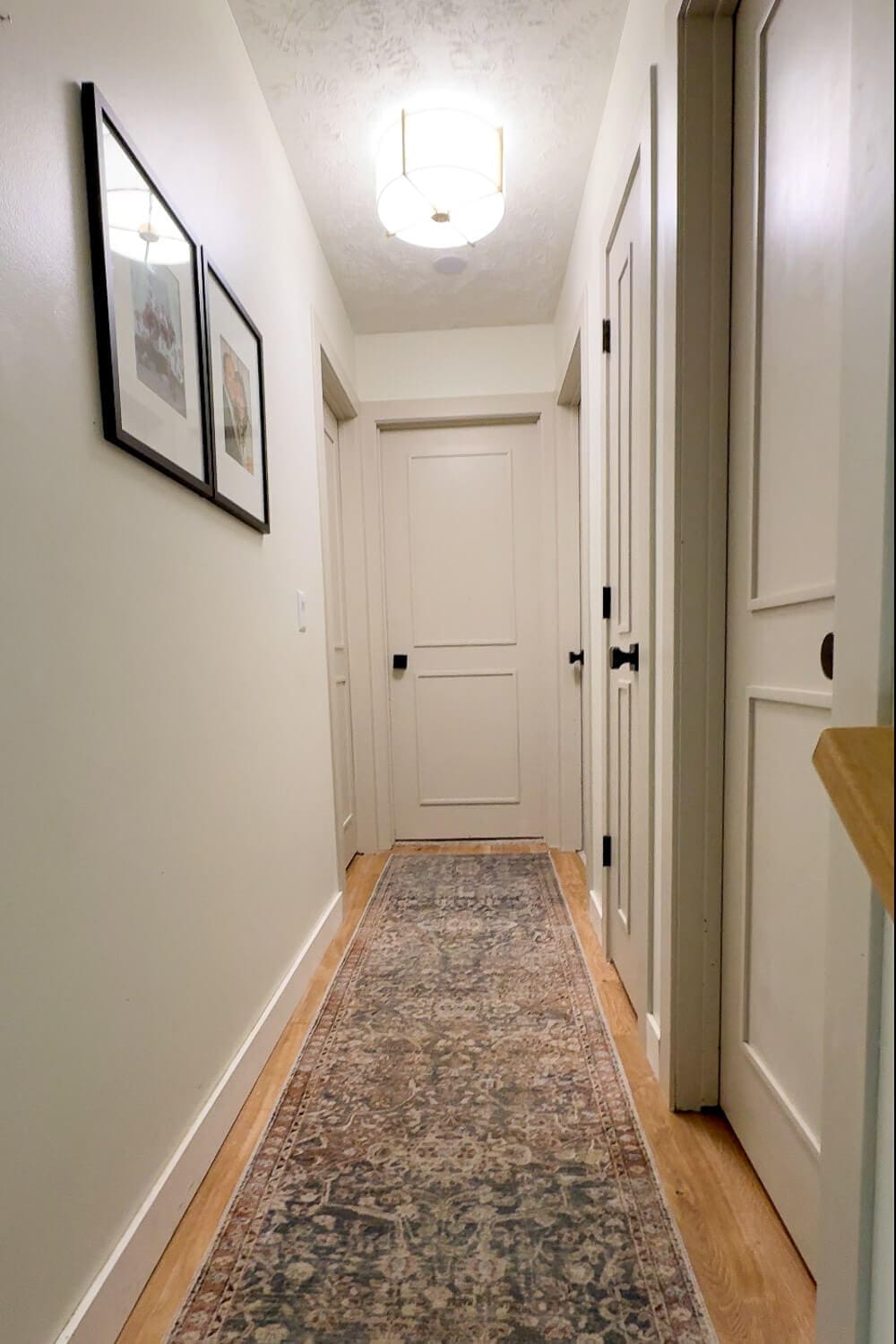 Finished hallway interior door upgrade with trim panels and black hardware
