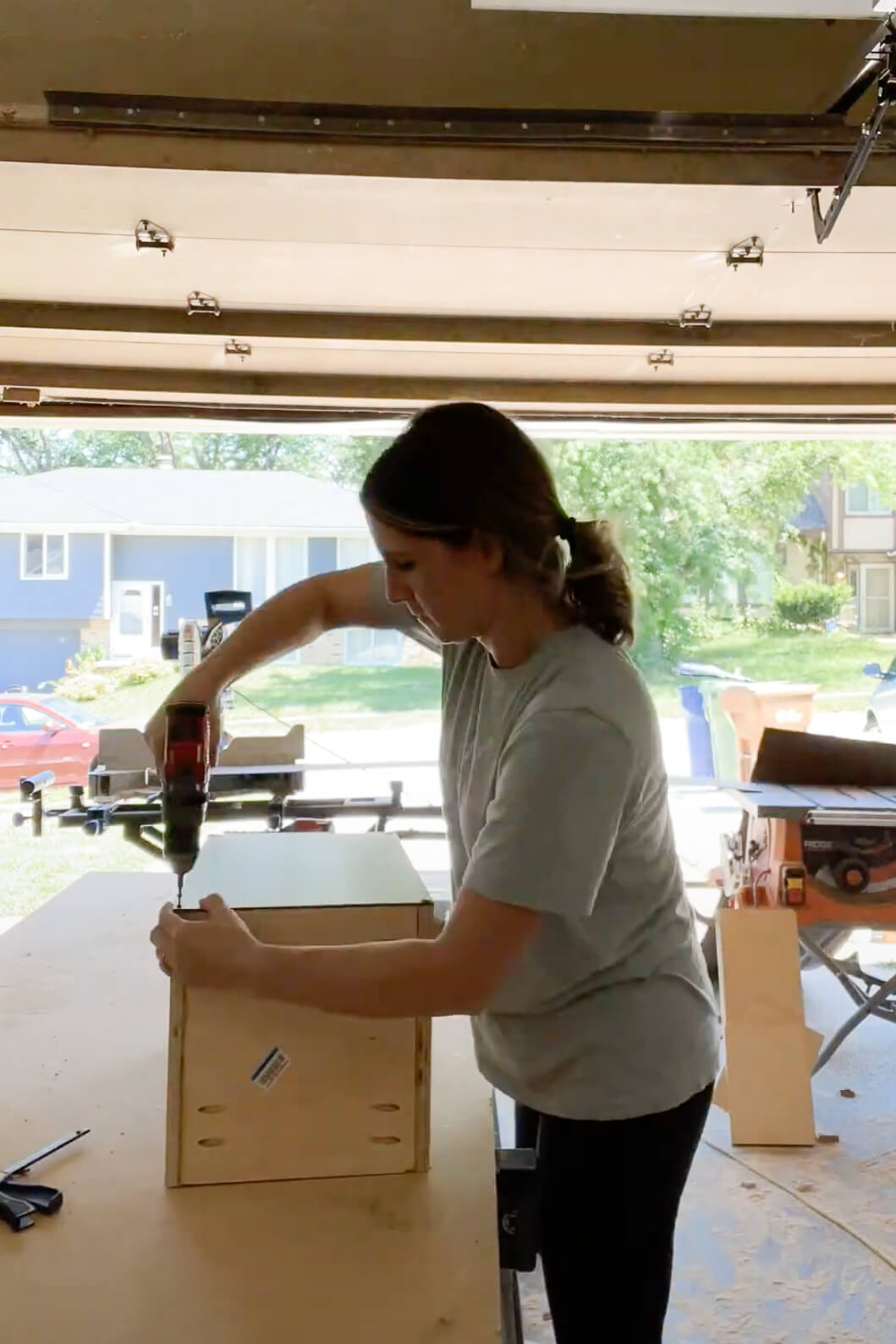 Woman building cabinet box for extending kitchen cabinets to the ceiling.