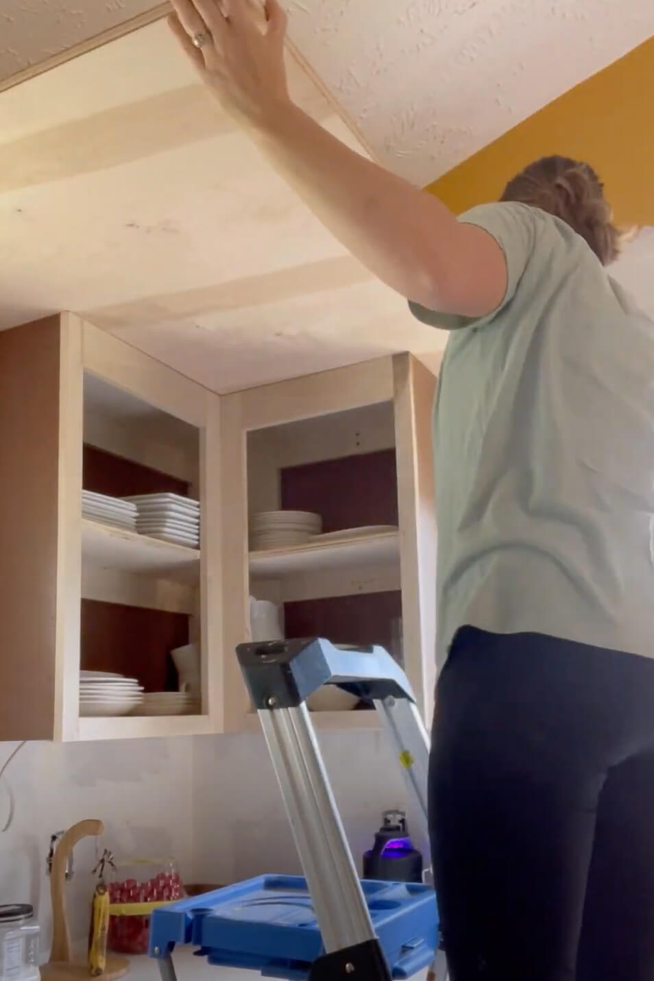Woman building kitchen cabinets.