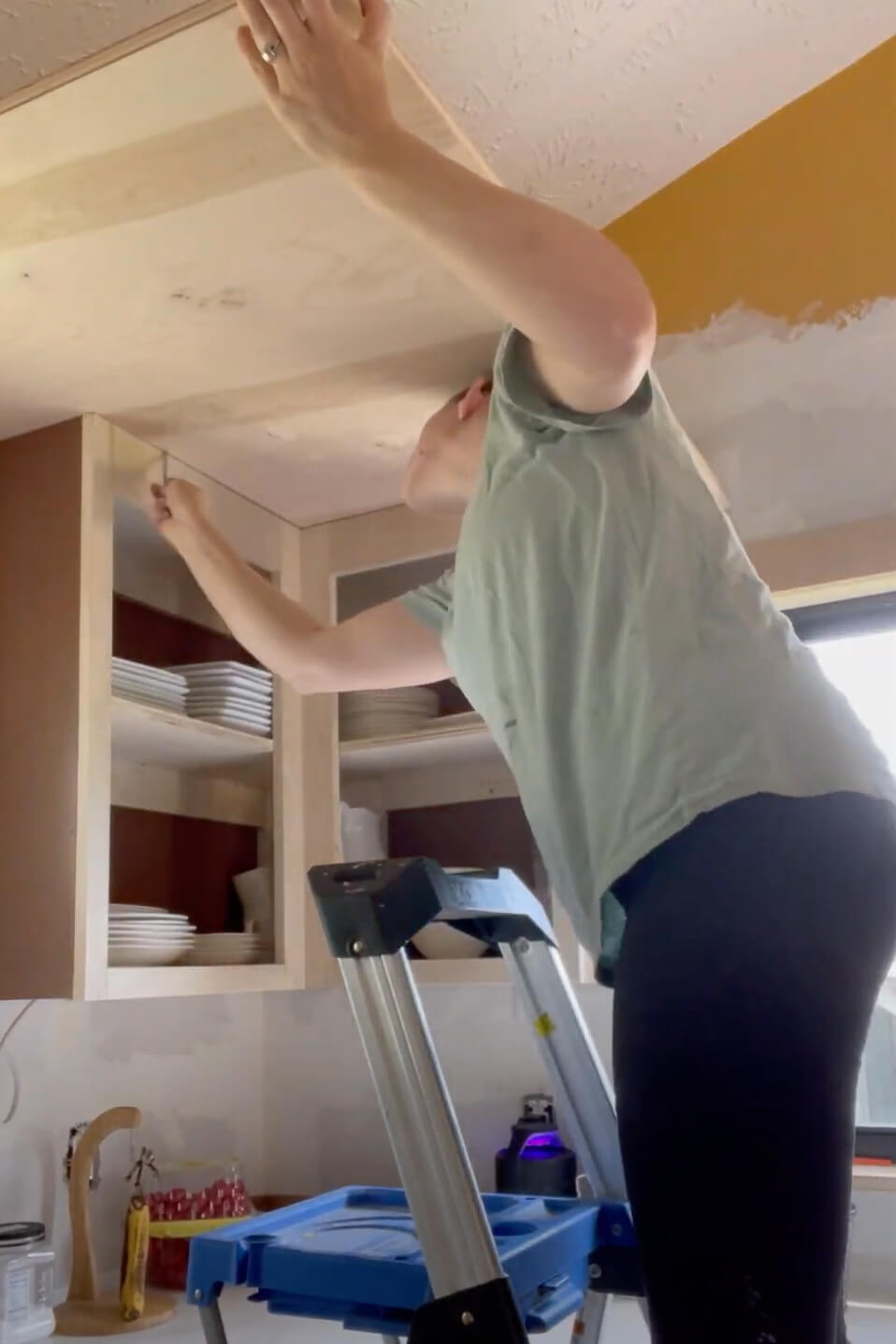 Woman building kitchen cabinets.