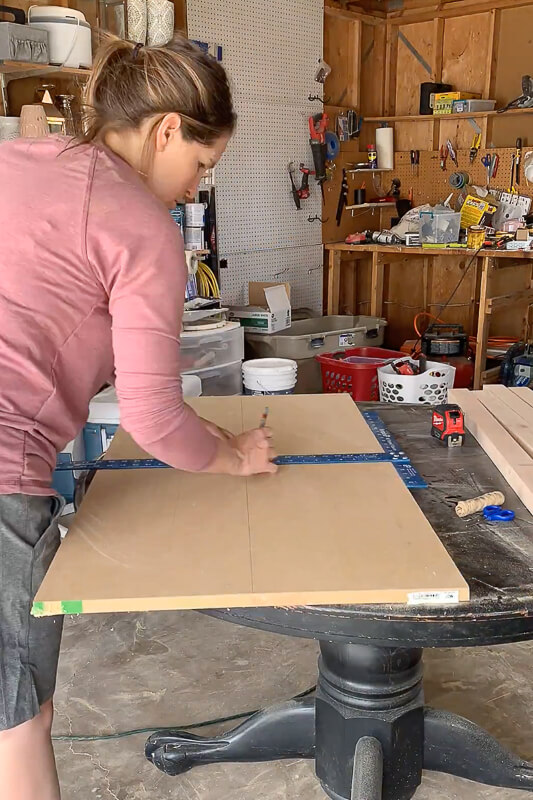 Woman measuring MDF for a DIY Marble Coffee Table