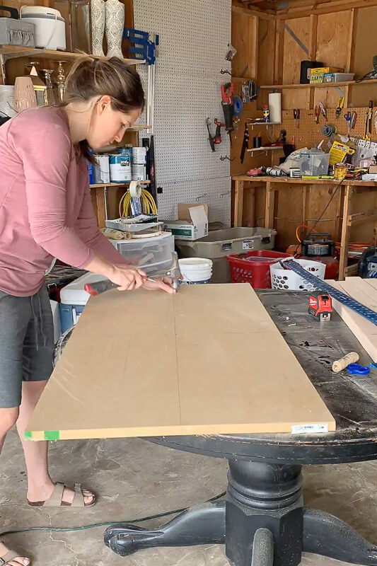 Woman drawing an oval on MDF