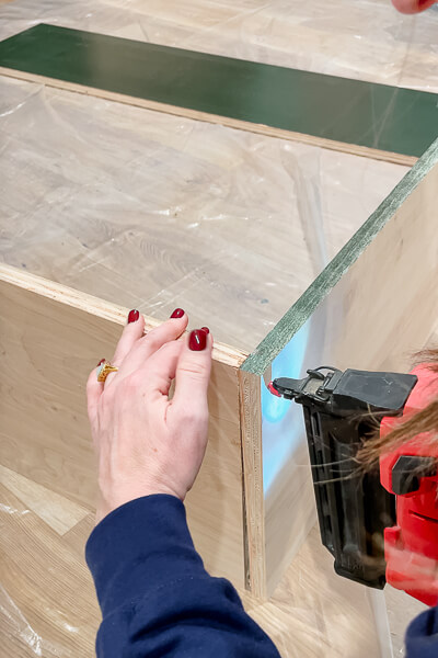 woman assembling cabinet boxes