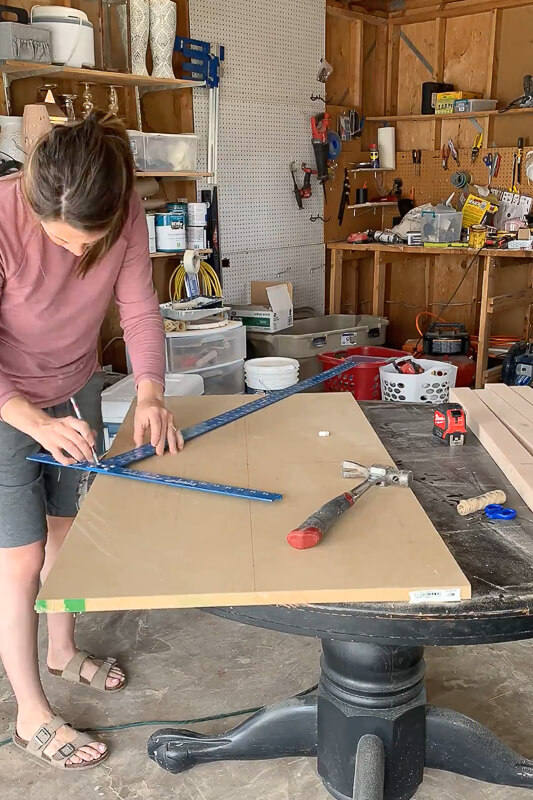 Woman using a T square to measure MDF