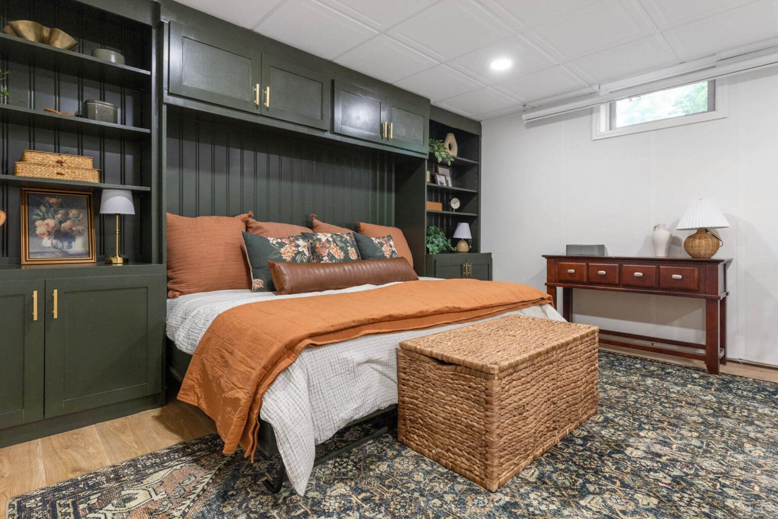 Full view of DIY horizontal Murphy bed in guest bedroom with dark green built-ins and cozy bedding setup