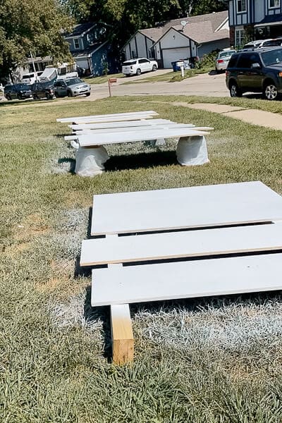 Primed Murphy bed panels drying in grass with foam and makeshift supports for painting