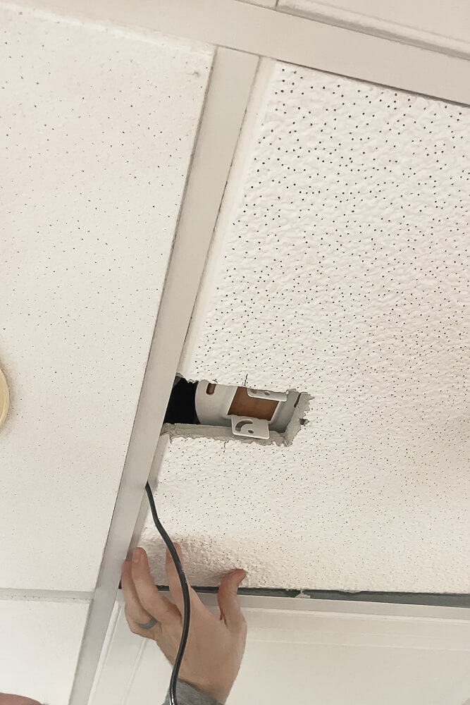 Cutting a drop ceiling tile with a razor