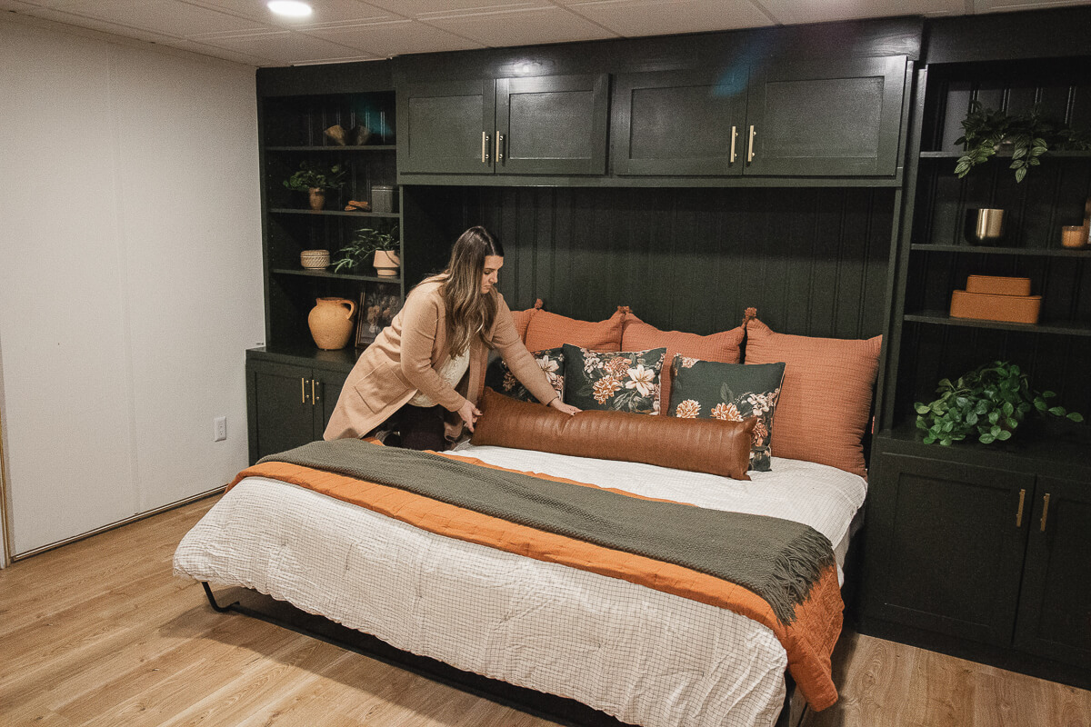 woman making the bed on a murphy bed