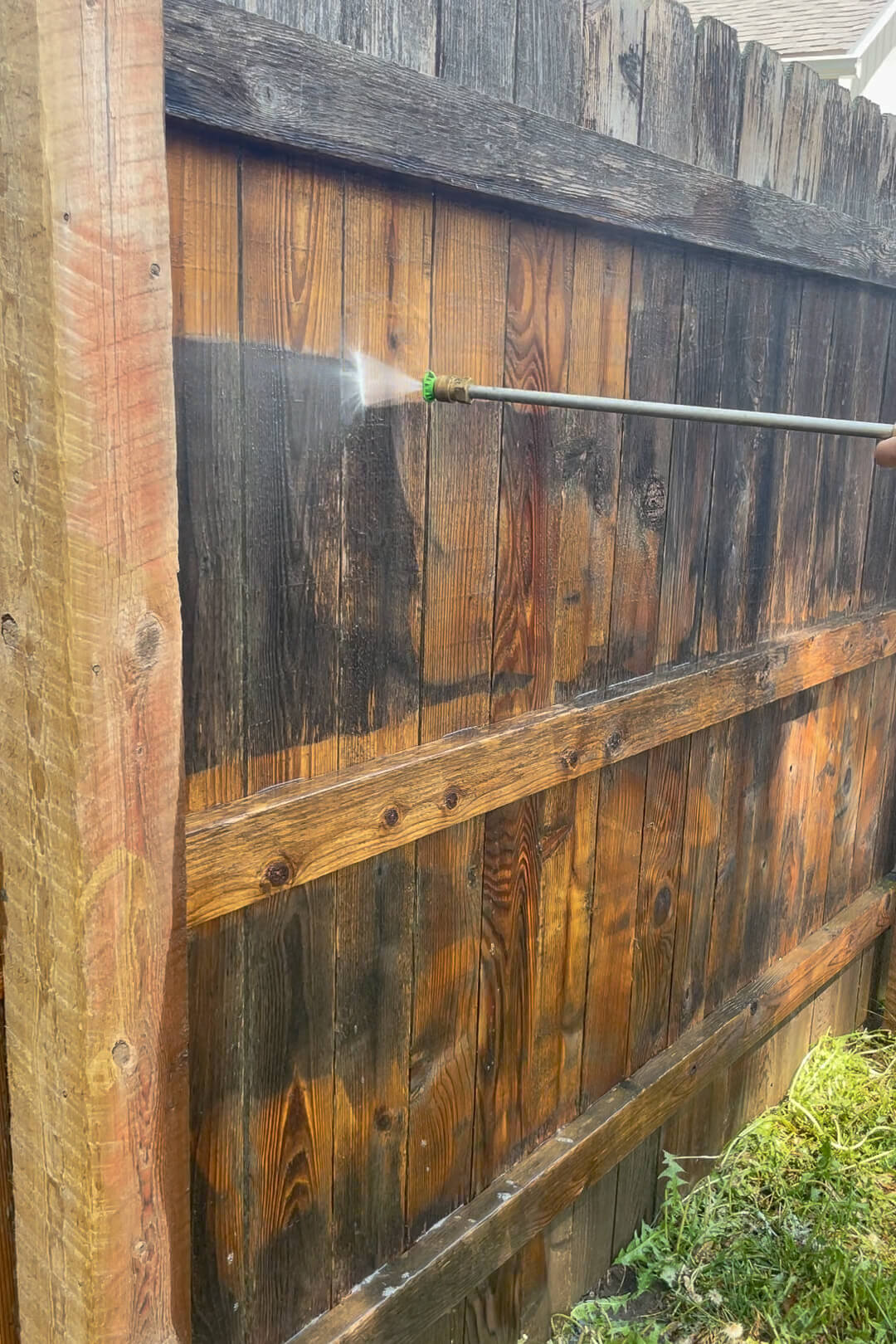 Pressure washing an old wood fence.