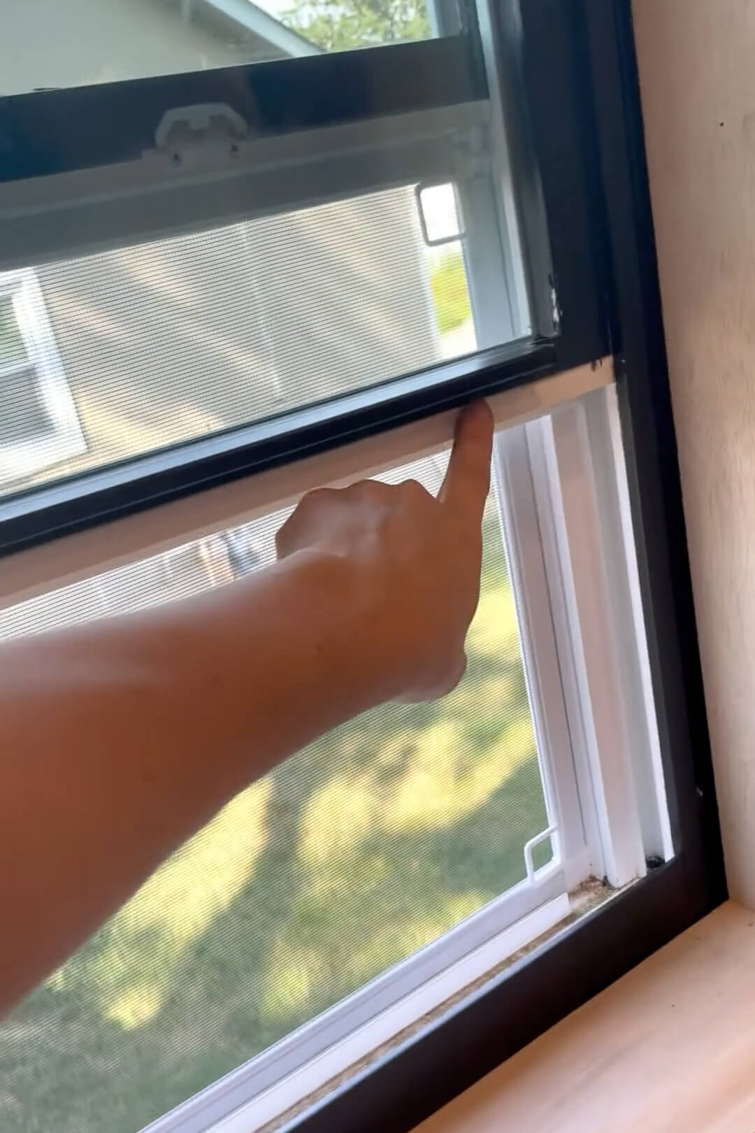 Painting a white, vinyl window with spray paint.