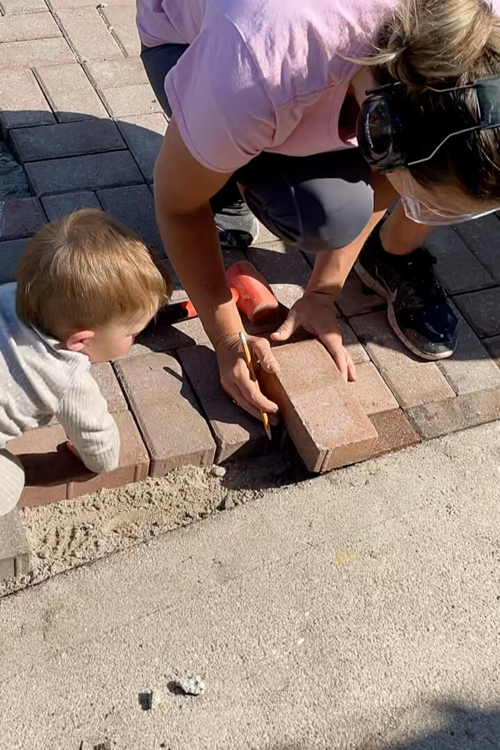Using a pencil to mark where to cut a paver using a tile saw.