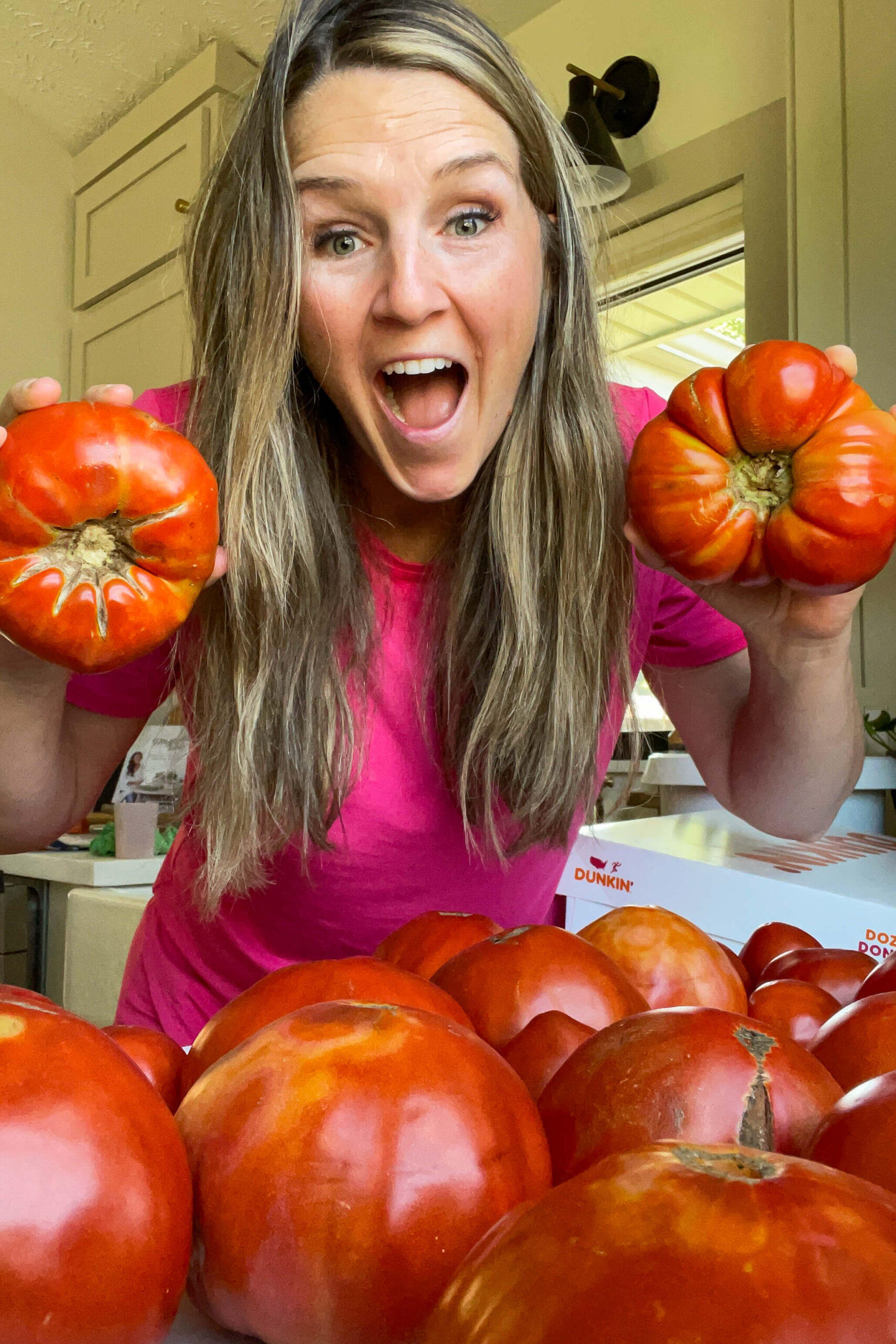Woman with abundance of tomatoes from her garden. 