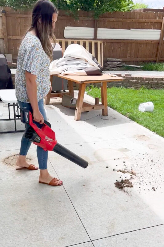 Using my handheld, cordless blower to clean up dirt on my patio.