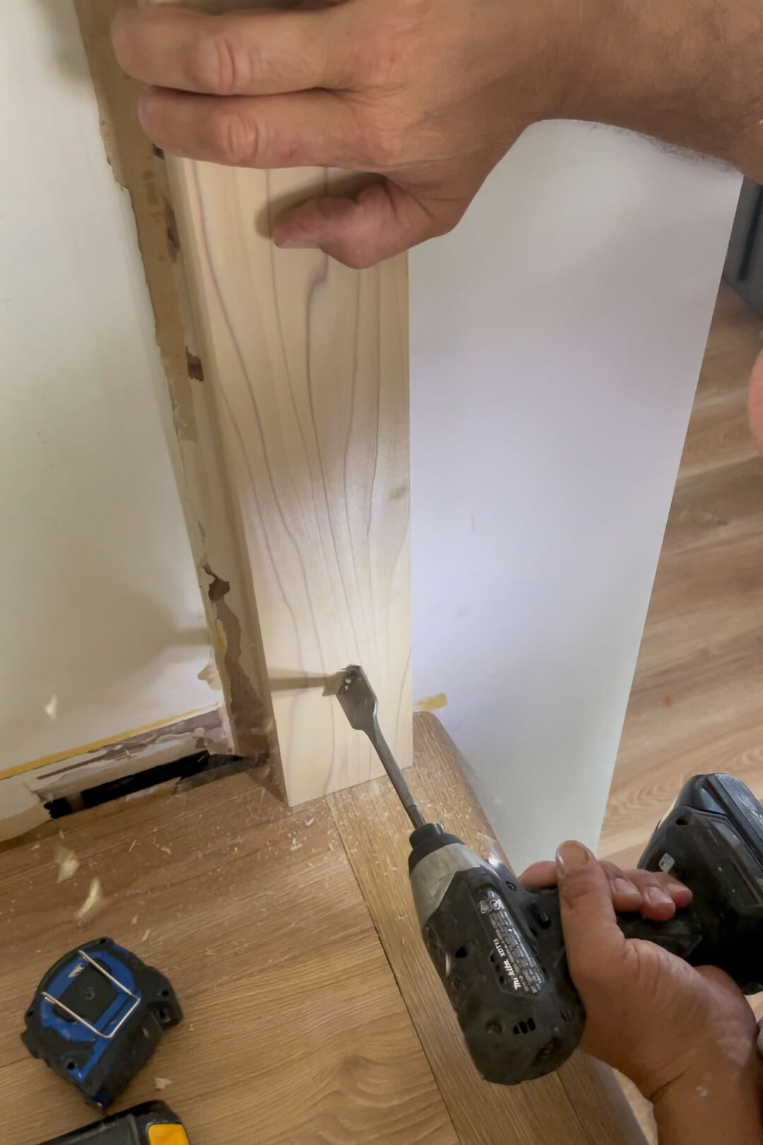 Using a spade bit to drill a hole in a newel post.