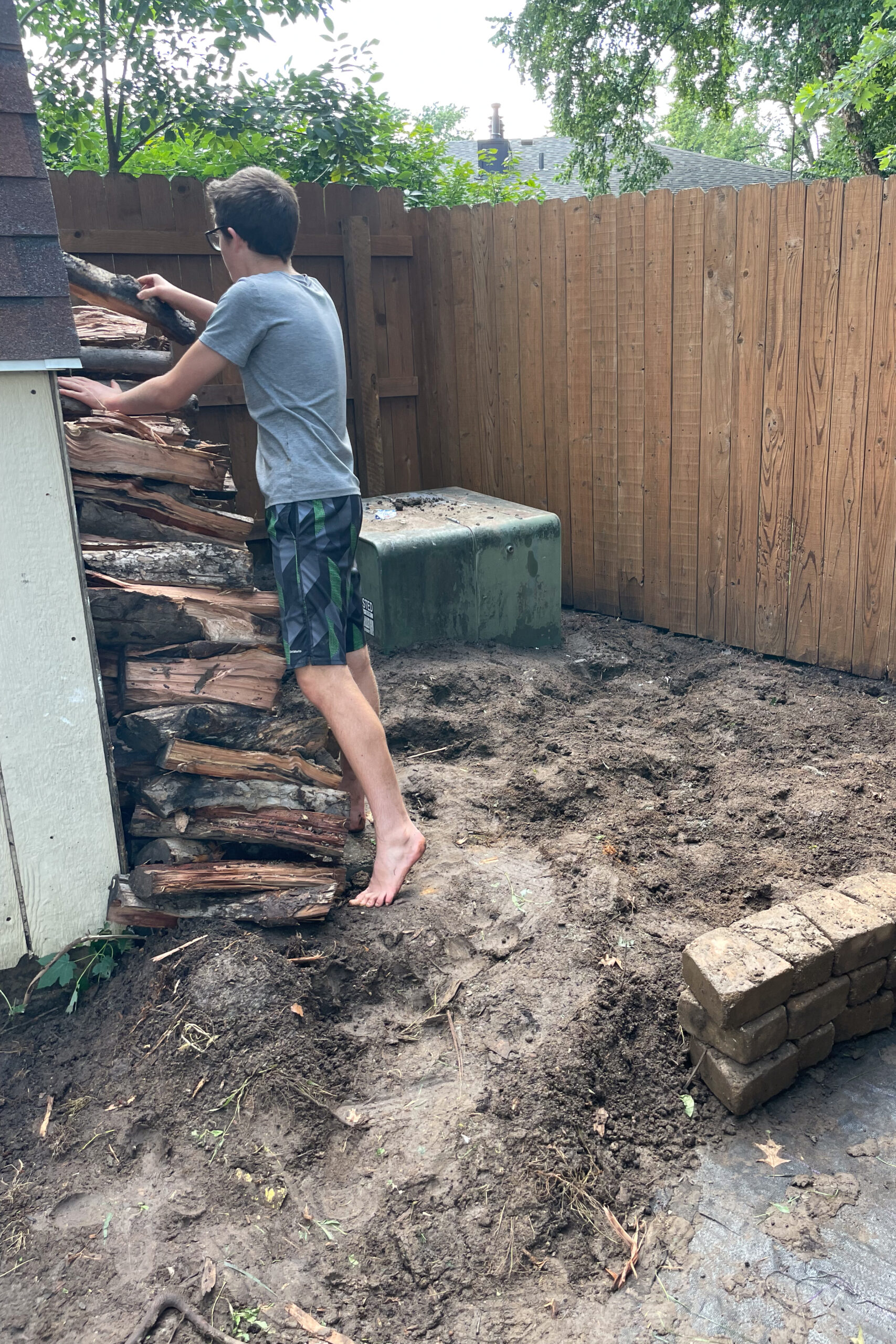 Stacking firewood on a small, DIY dry pour concrete pad.