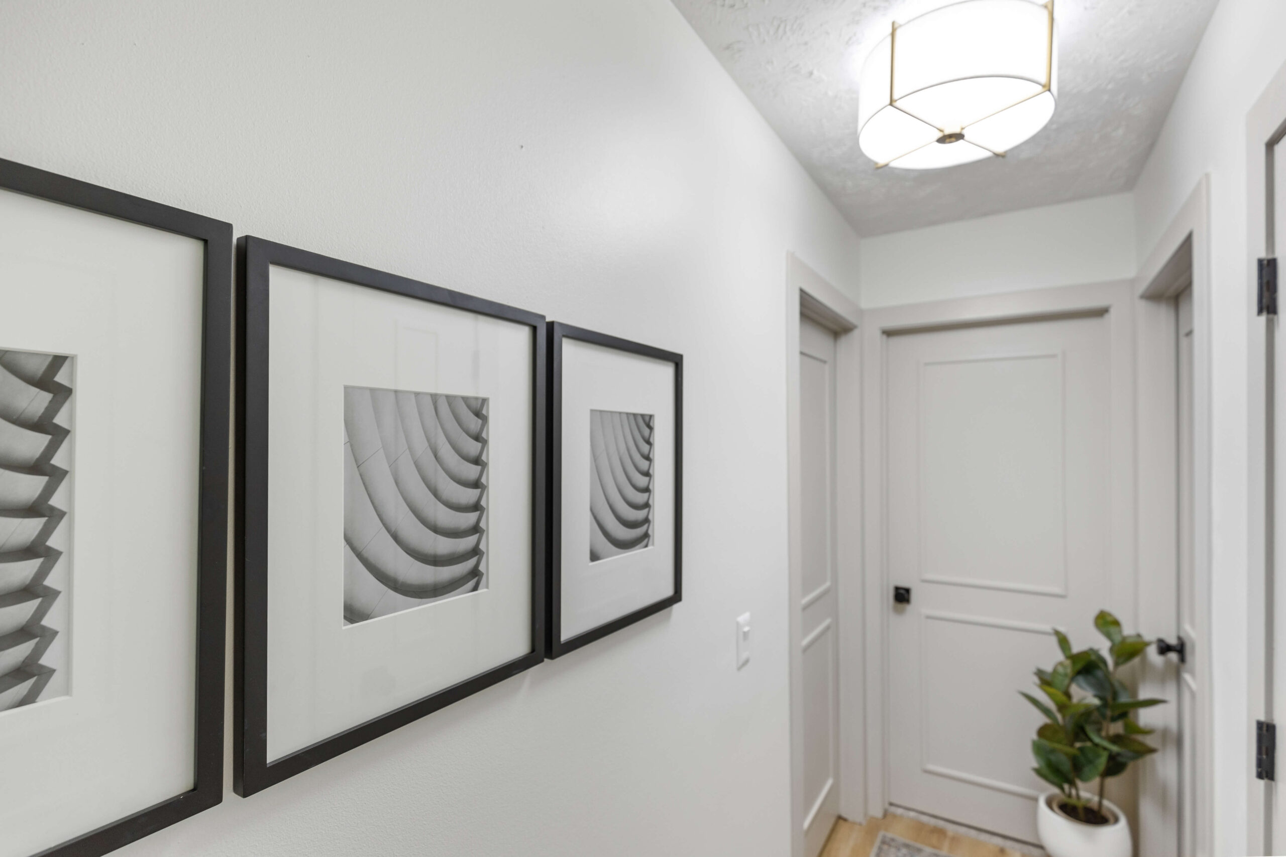 Hanging artwork in a gallery wall layout in a hallway.