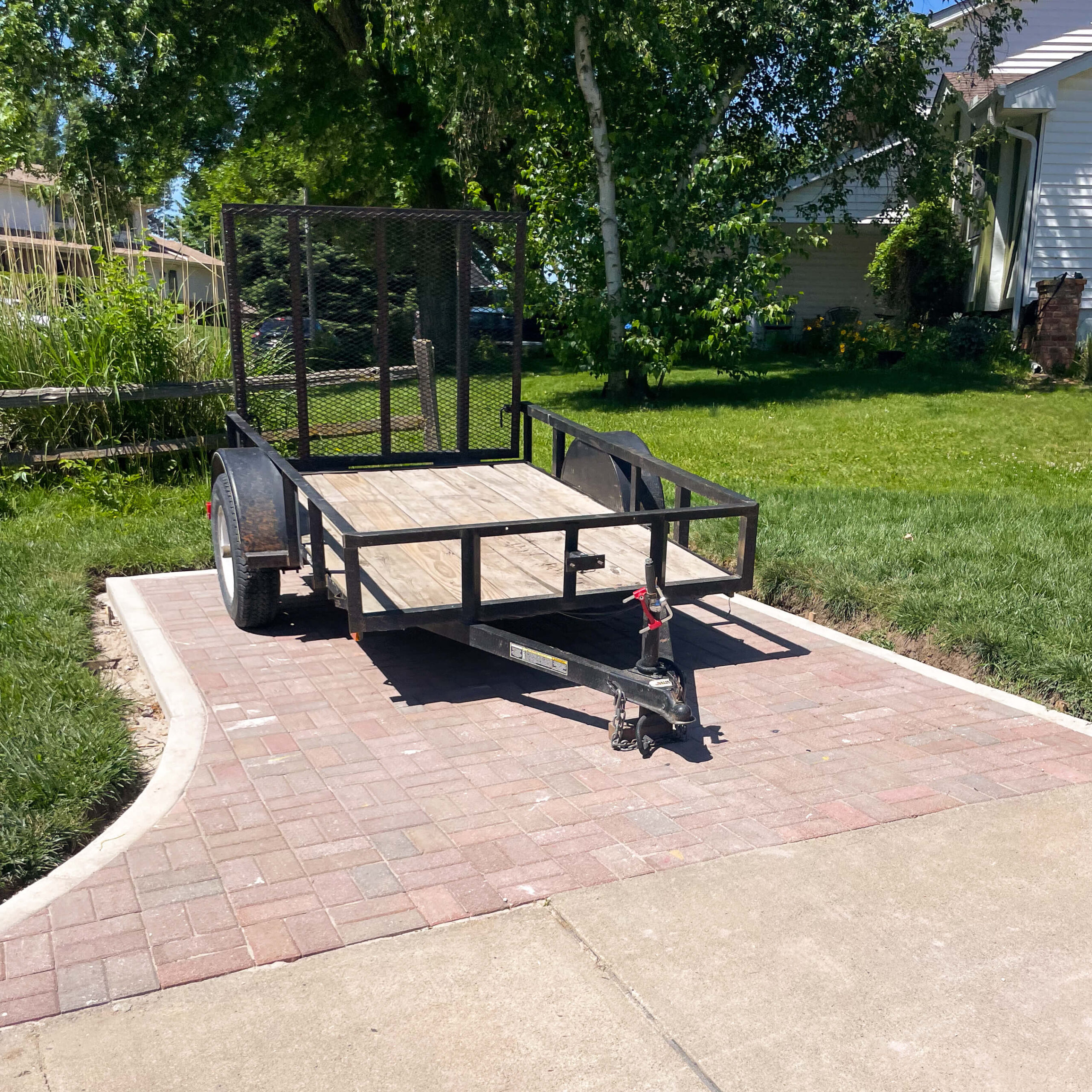 The after photo of a DIY paver patio built for trailer parking.