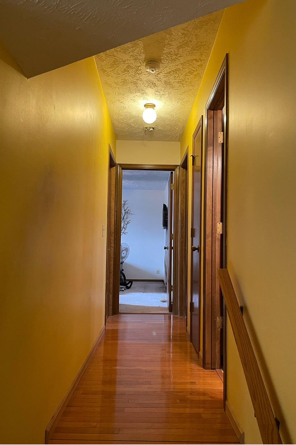 Before picture of a yellow, ugly hallway. 