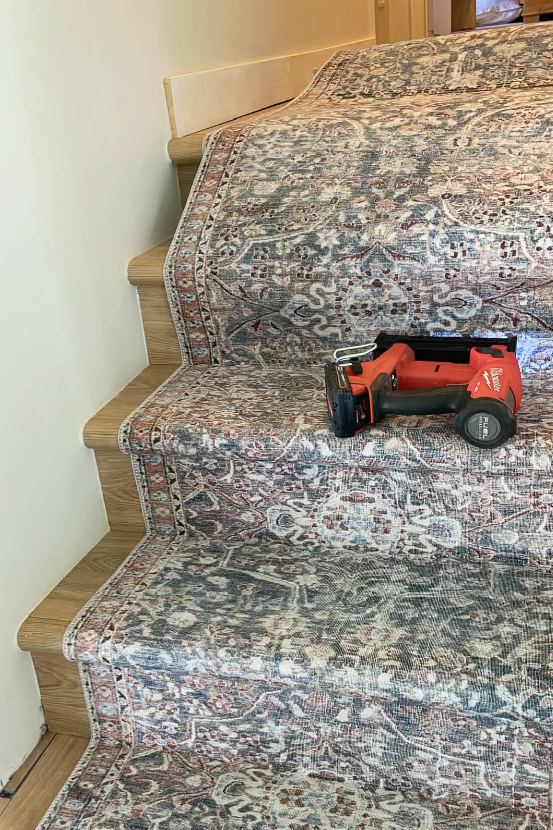 Stapling a stair runner to stairs.