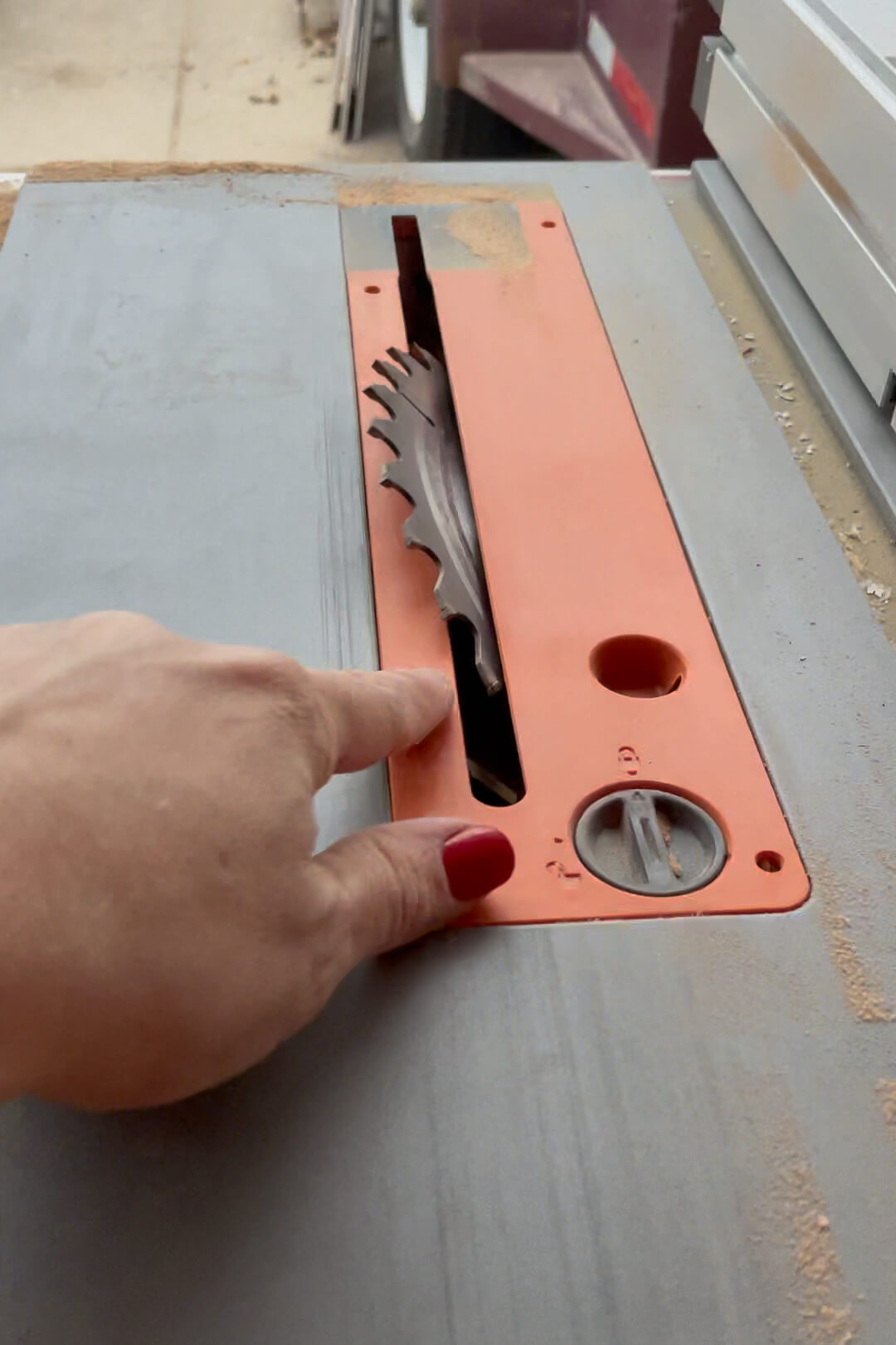 Adjusting the table saw blade to 45° angle.