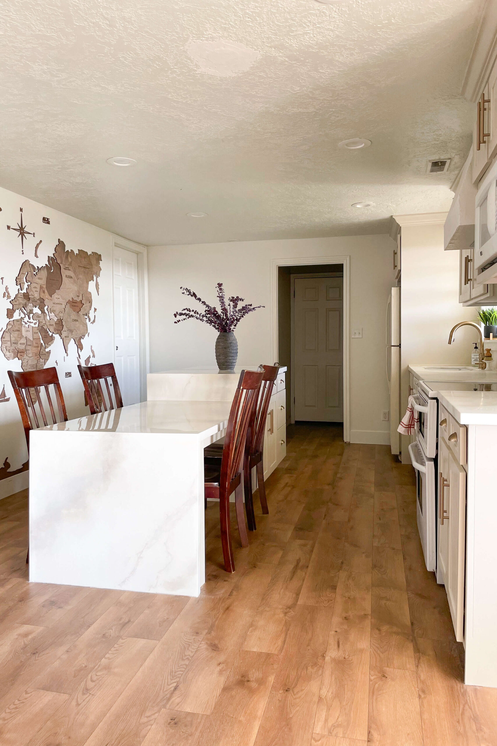 Waterfall kitchen island in the middle of a DIY remodeled kitchen. 